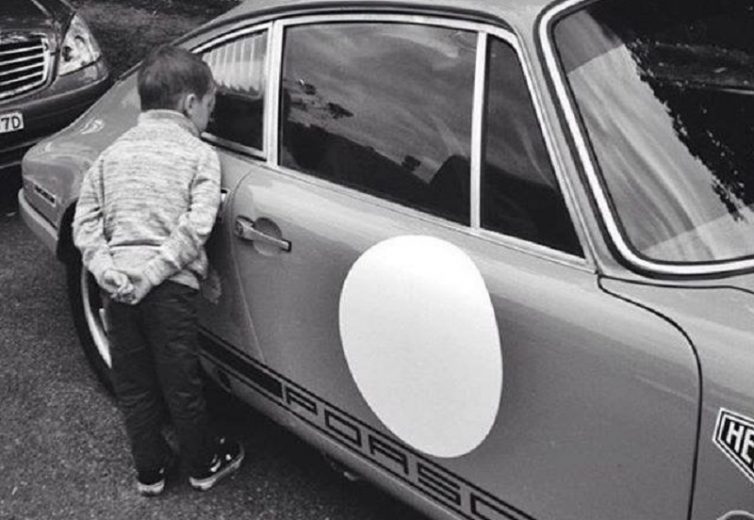 Criança a olhar para interior do Porsche 911