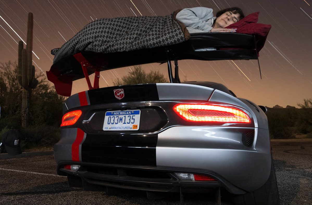 Pessoa a dormir na asa traseira do Dodge Viper