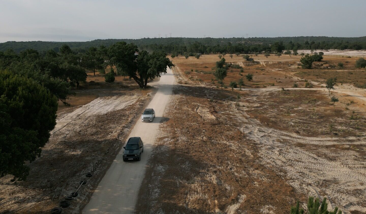 Panorâmica sobre terreno com Jeep Renegade 4xe e Compass 4xe