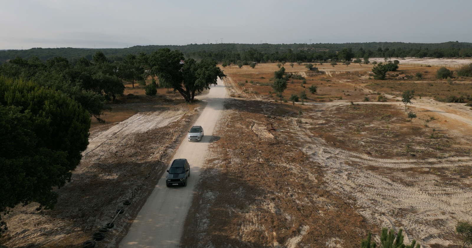 Panorâmica sobre terreno com Jeep Renegade 4xe e Compass 4xe