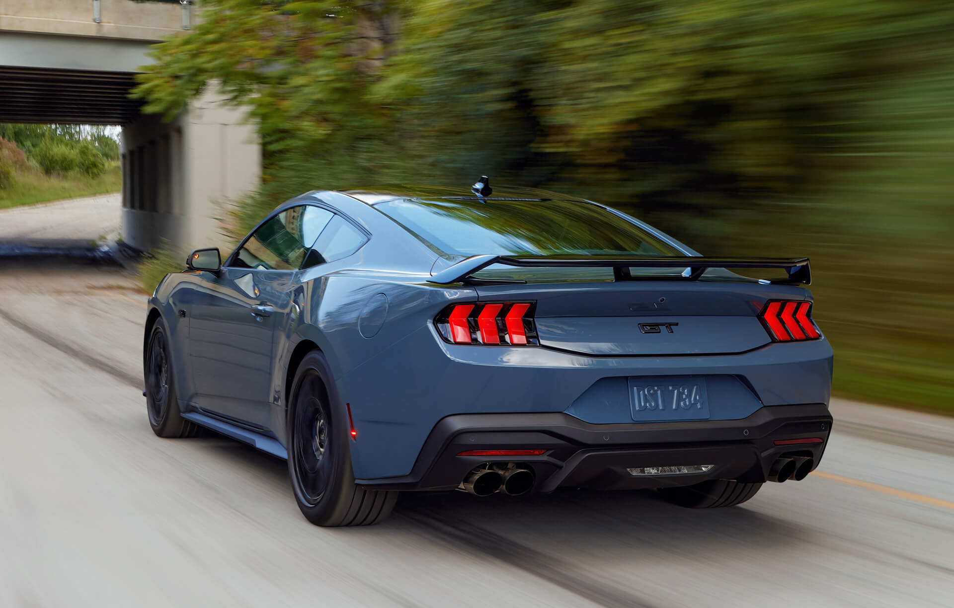 Ford Mustang GT em movimento vista traseira 3/4