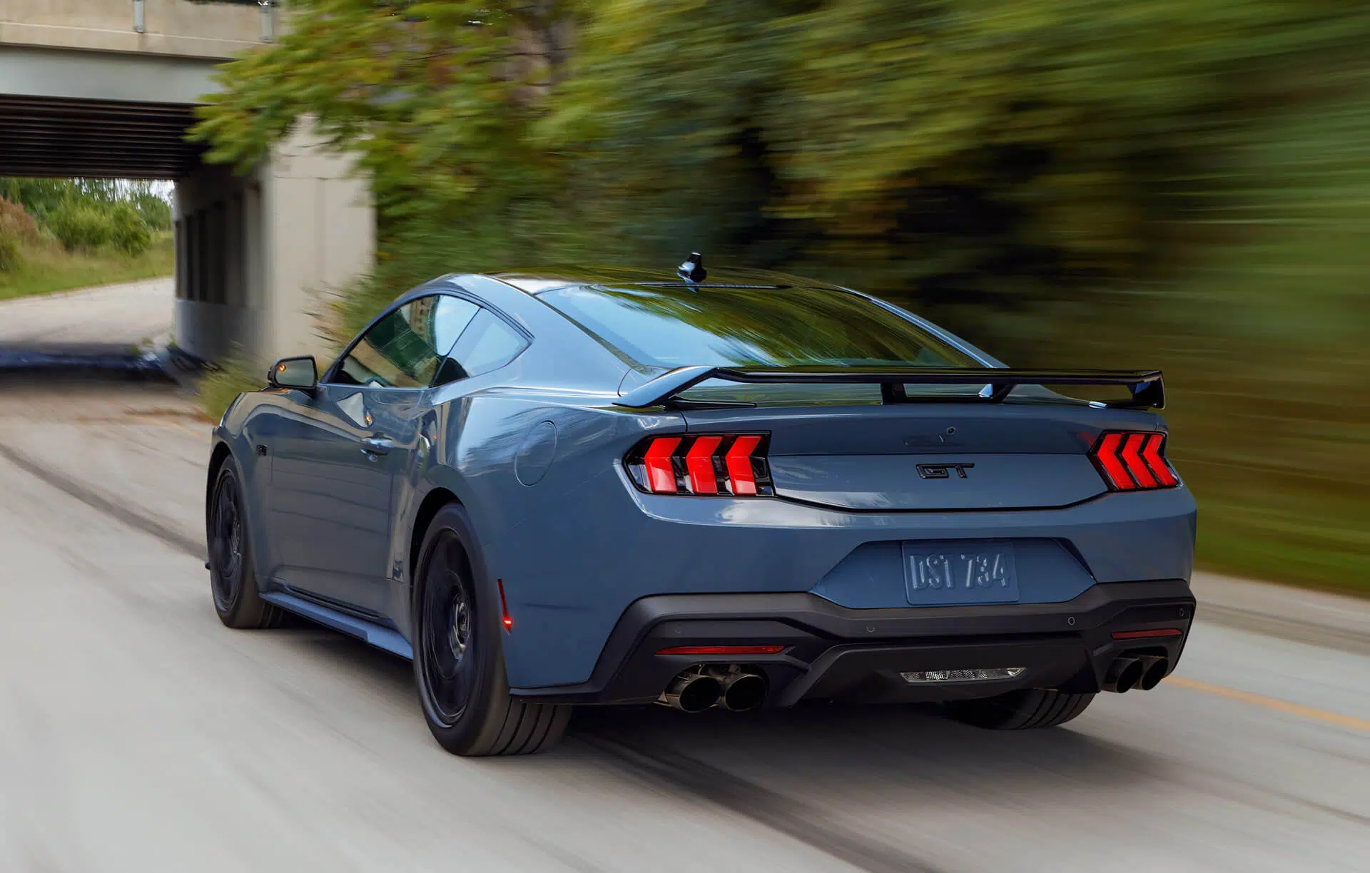 Ford Mustang GT em movimento vista traseira 3/4
