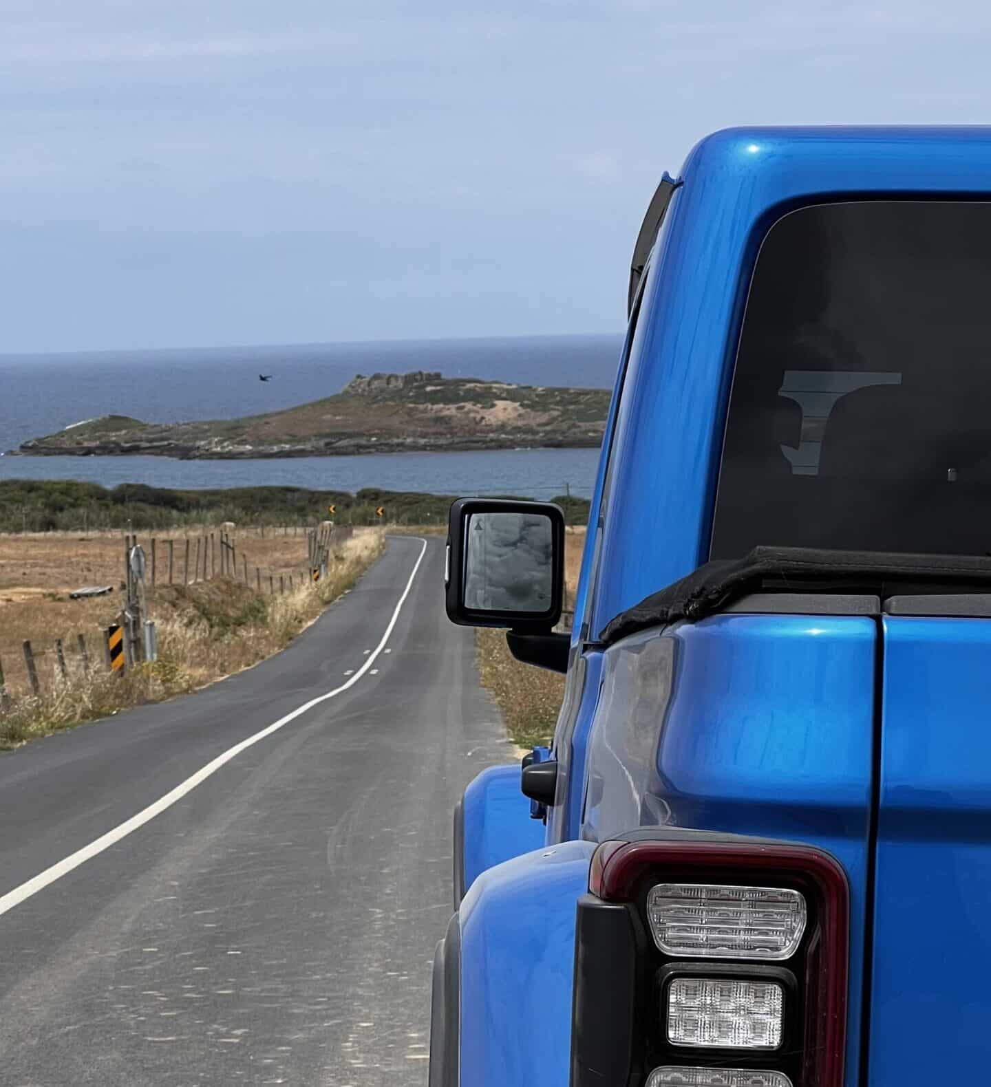 JEEP Gladiator detalhe traseira com vista para estrada e mar ao fundo