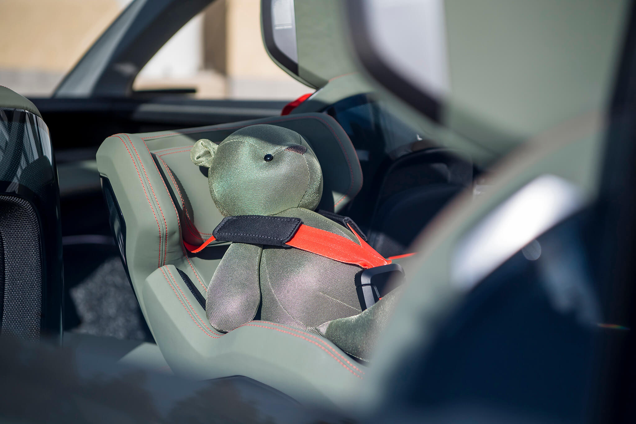 Urso de peluche na cadeira de bebe ao centro do havbitáculo