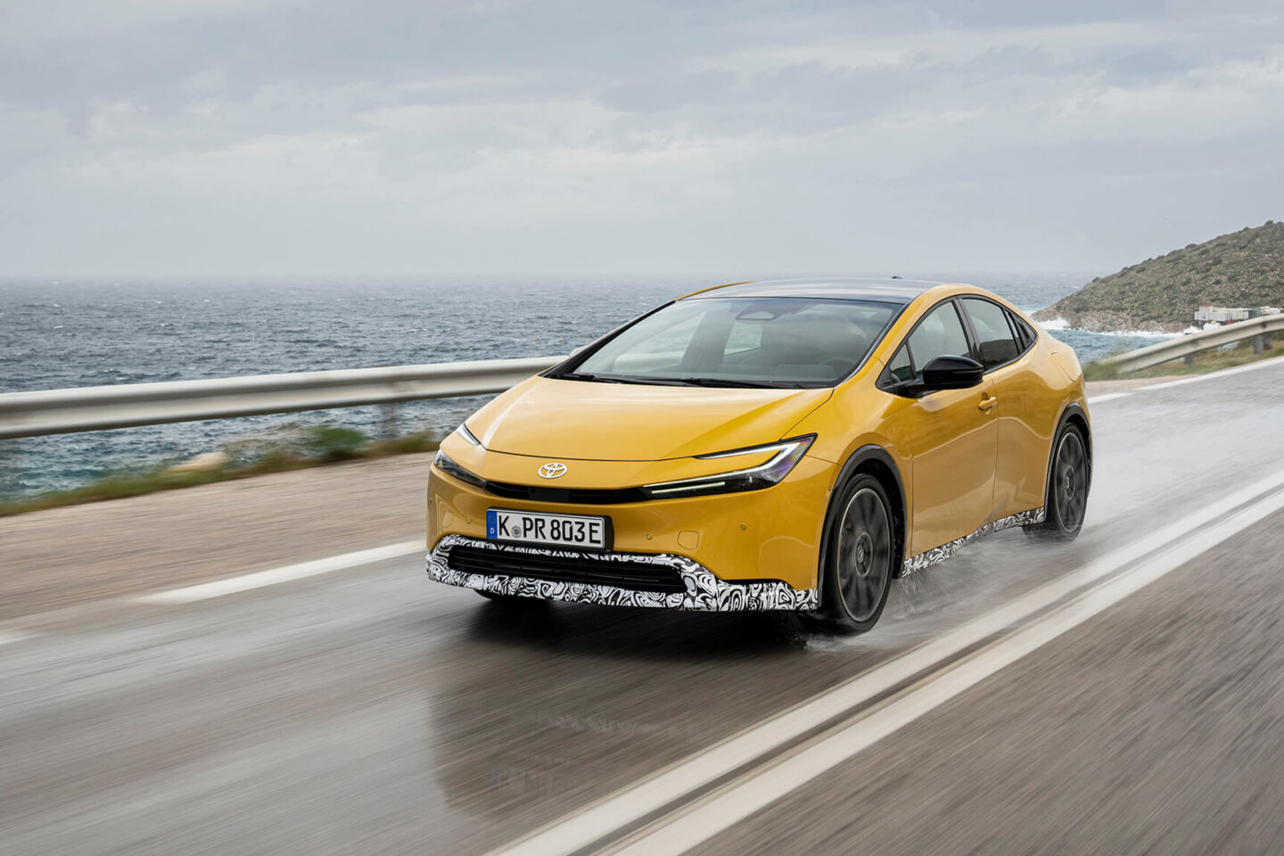 Toyota Prius na estrada molhada, vista de frente 3/4