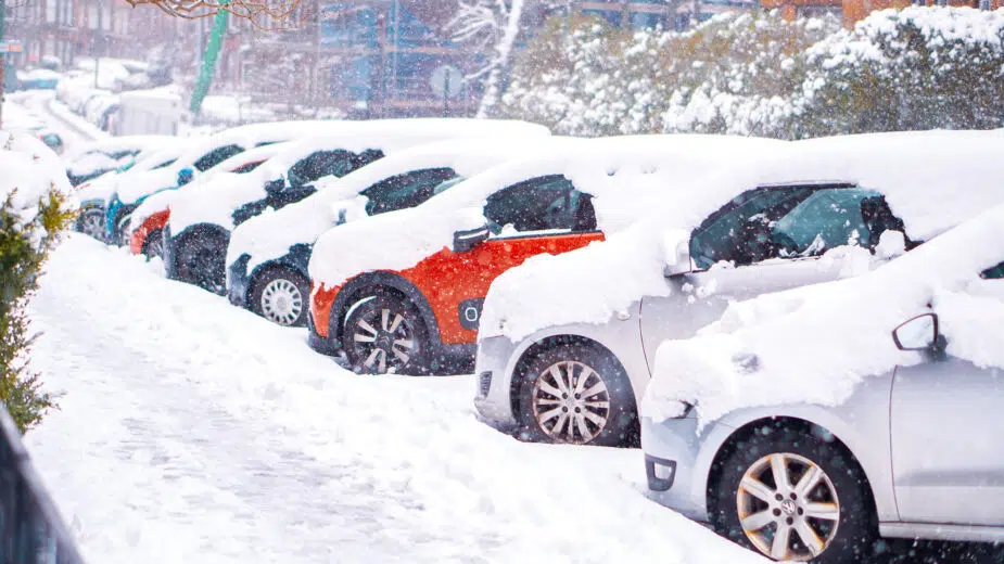 Carros estacionados em espinha em rua cheia de neve