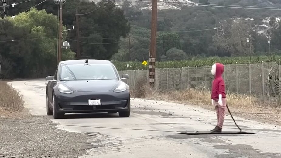 Tesla Model 3 na estrada com "boneco de testes" a atravessar estrada
