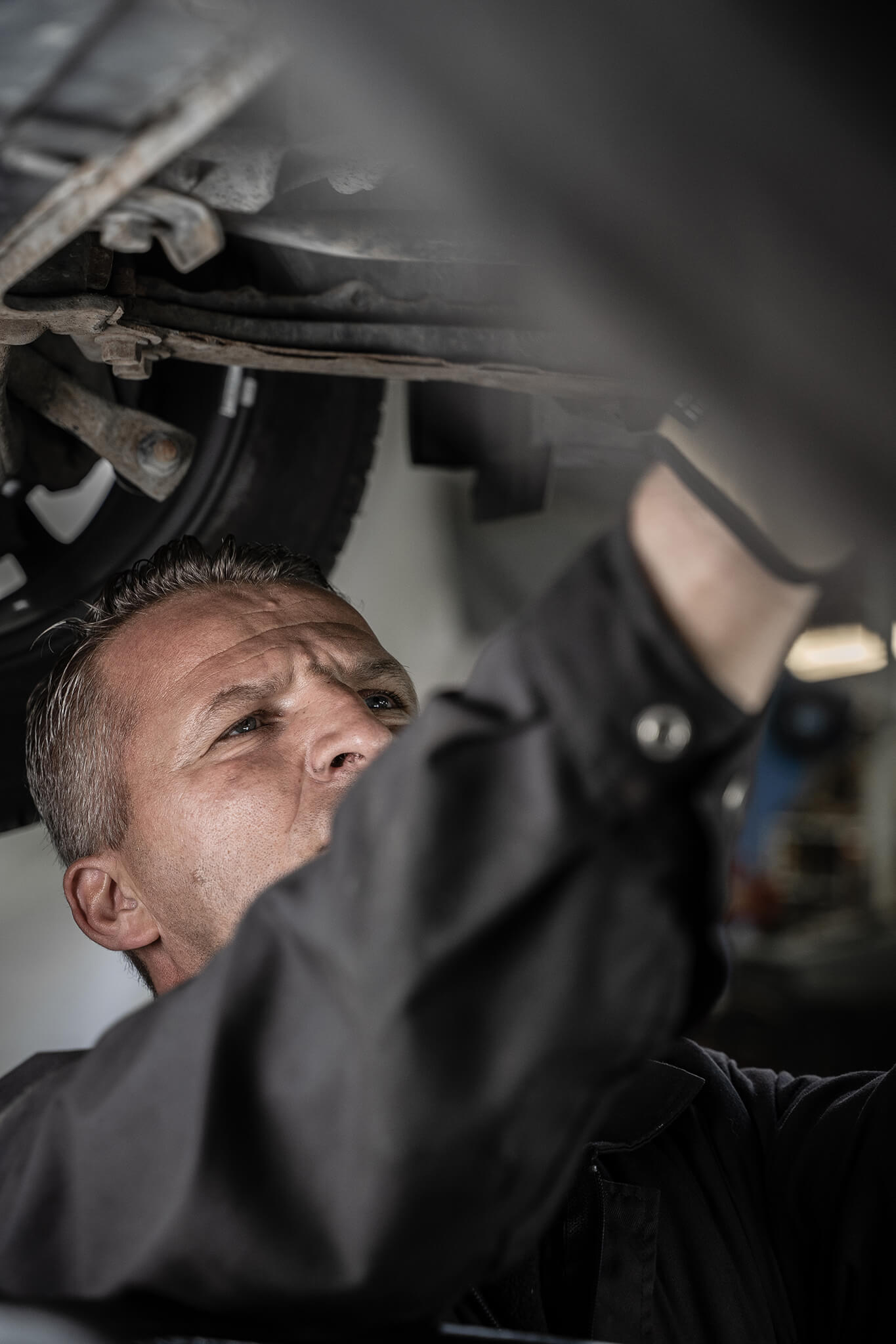 Mecânico a trabalhar por debaixo do automóvel