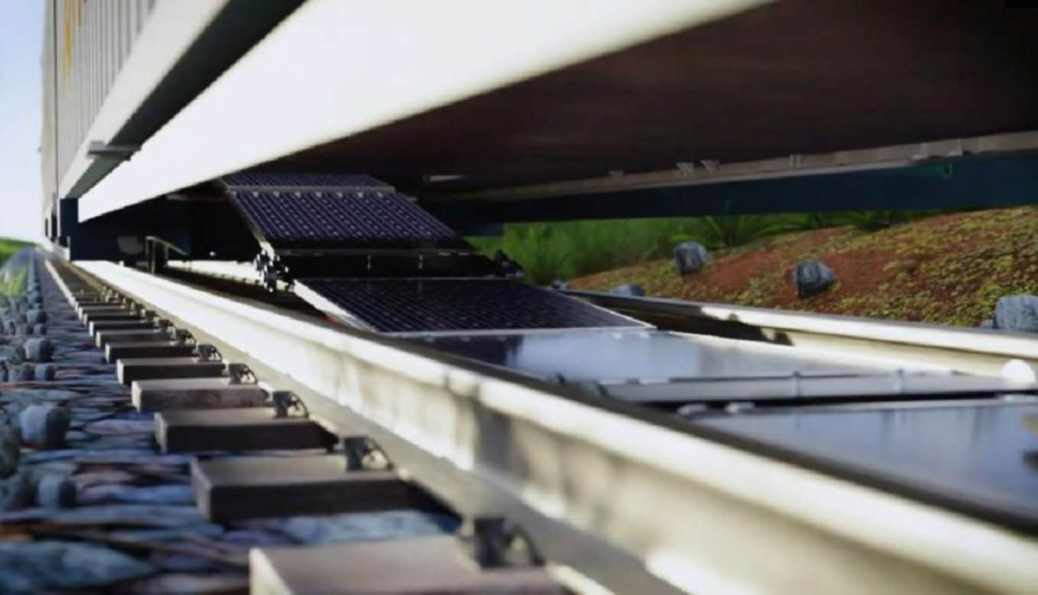 Vista aproximada de vagão a colocar painéis solares na linha de comboio