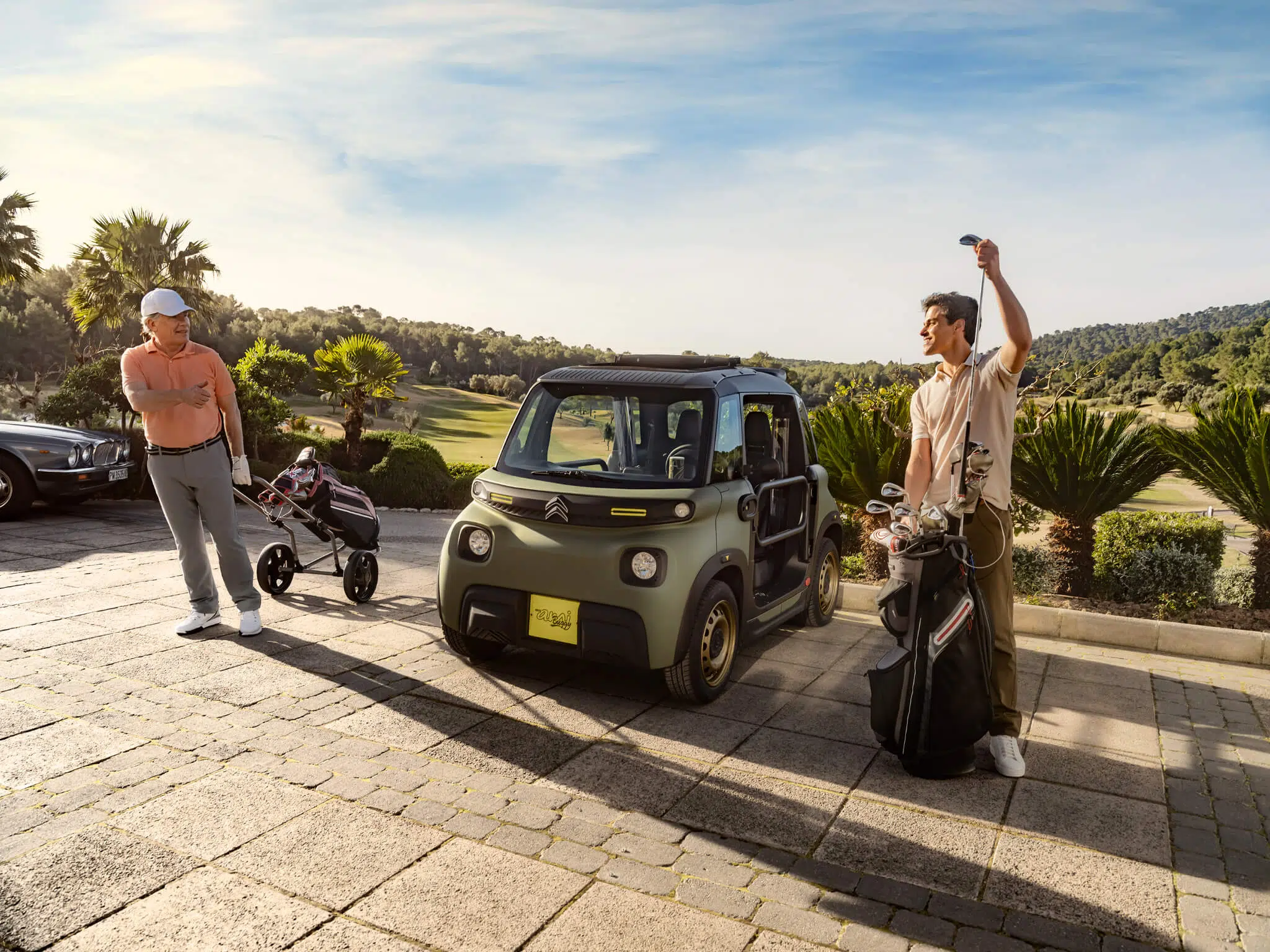 Citroën My Ami Buggy, frente com dois jogadores de golfe a ladeá-lo