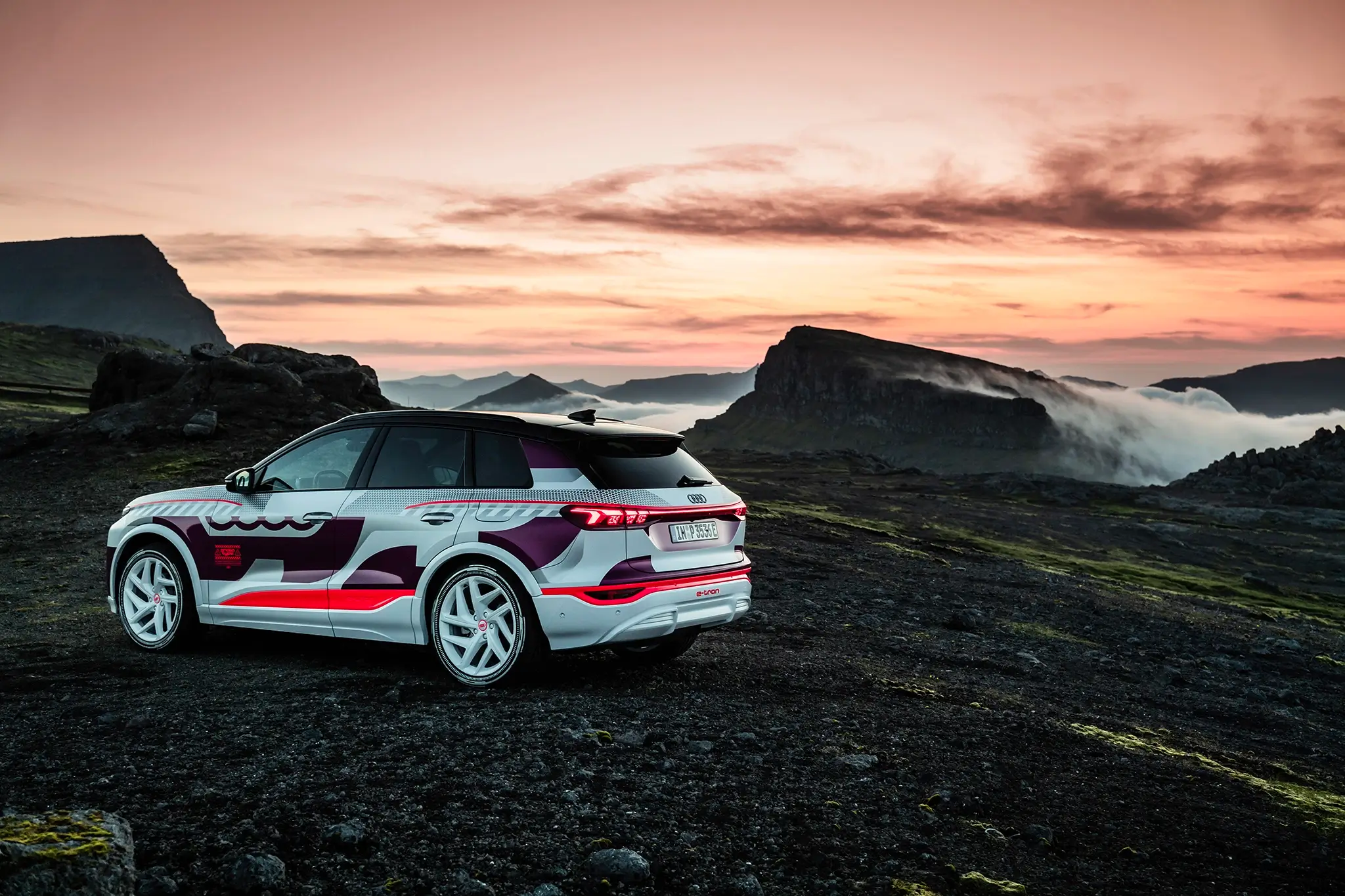Audi Q6 e-tron 3/4 de traseira com cenário rochoso