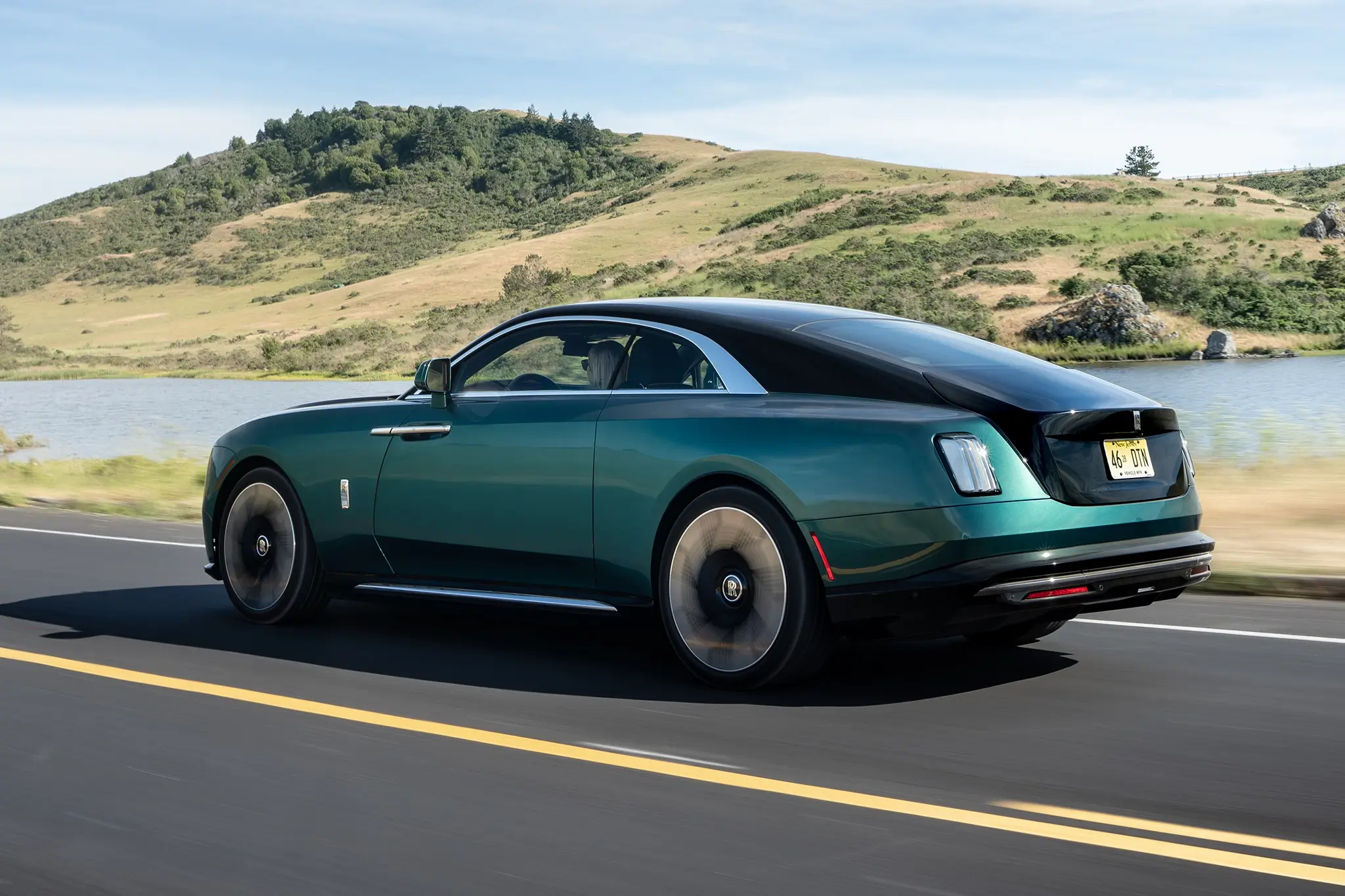Rolls-Royce Spectre verde visto de traseira e em movimento