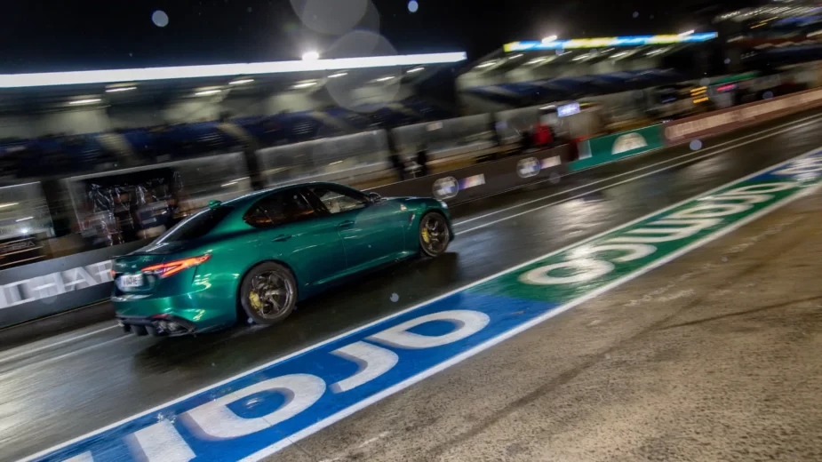 Alfa Romeo Giulia quadrifoglio 2023 em circuito, traseira 3/4, de noite