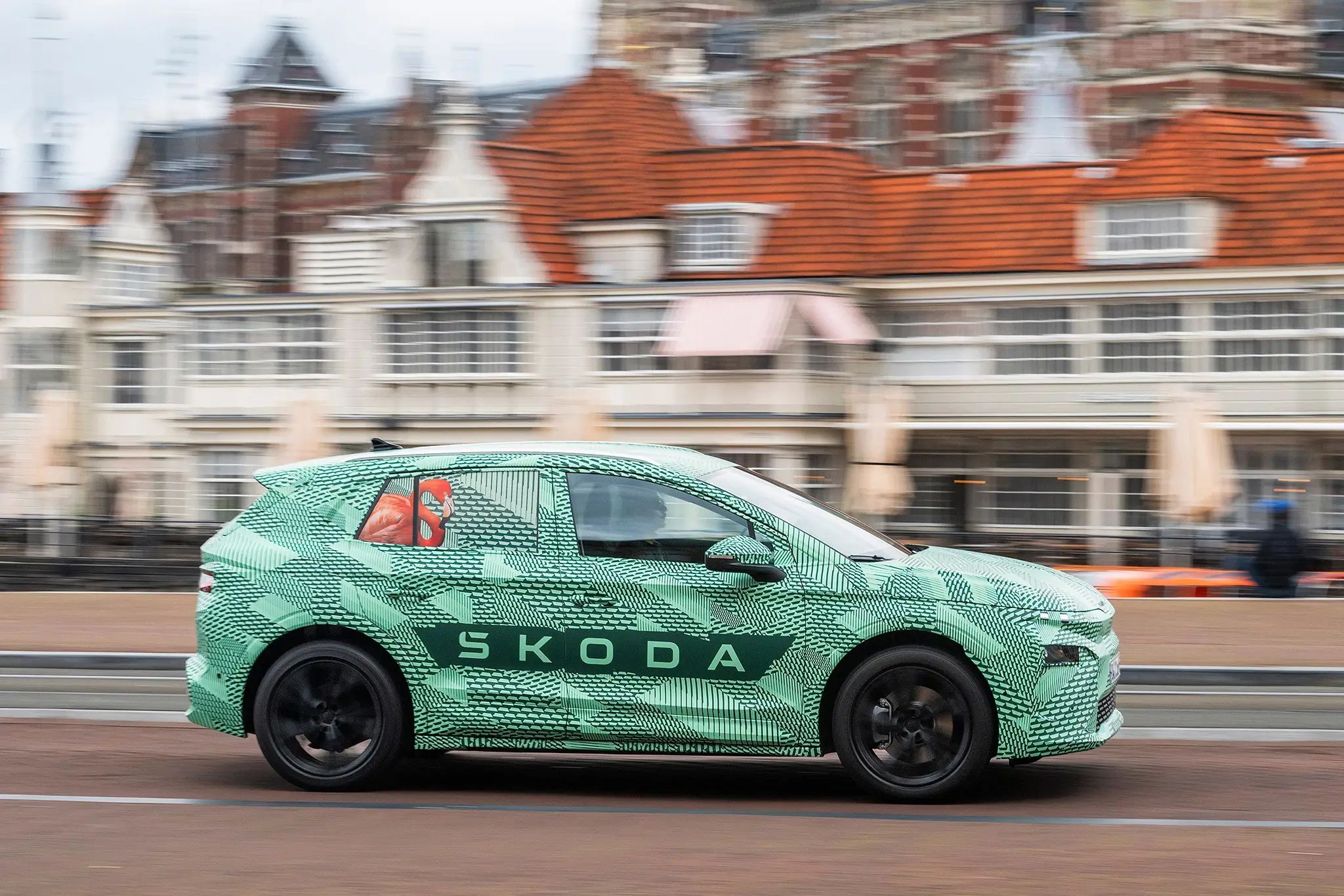 Skoda Elroq camuflado - vista lateral com prédios de fundo
